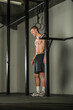 © qunica.com - Handsome bodybuilder doing pull-ups on horizontal bar in a indoors modern gym.