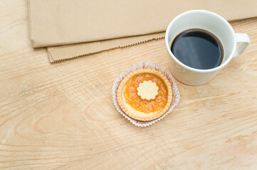 Canvas Print - delicious jam short crust pastry and black coffee cup on a food paper and rustic wood background