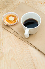 Canvas Print - delicious jam short crust pastry and black coffee cup on a food paper and rustic wood background