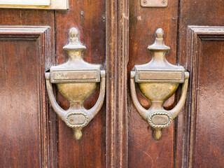 Poster - Portugal, Tomar. Old brass door knockers on an old door along the streets of Tomas.