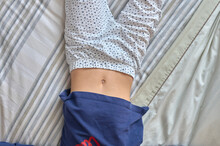 Girl Lying On A Bed With Her Belly Button Exposed