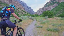 Man Gets On Mountain Bike In Rock Canyon And And Starts Riding On Trail