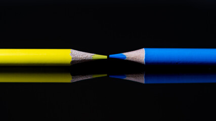 Canvas Print - Closeup shot of yellow and blue pencils on a dark background