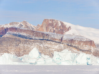 Wall Mural - Icebergs frozen into the sea ice of the Uummannaq fjord system during winter. Greenland, Danish Territory