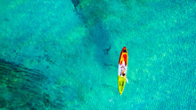 Aerial View Of A Kayak In The Blue Sea .Woman Kayaking She Does Water Sports Activities.