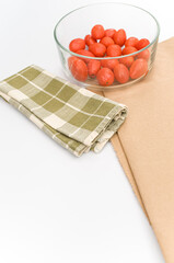 Poster - fresh organic datterini tomatoes in a glass bowl on a white table background