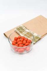 Poster - fresh organic datterini tomatoes in a glass bowl on a white table background