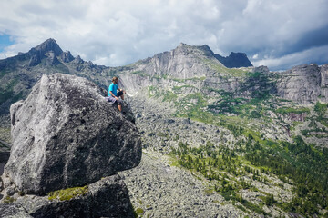 Hiker on top of a rock with a beautiful view of Ergaki natural practice