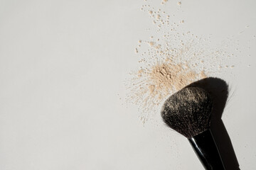 Close up of neutral beige make up cosmetic powder sprinkle and makeup brush on white background. Aesthetic minimalist beauty branding, merchandise sample concept