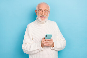 Sticker - Portrait of attractive cheery skilled grey-haired man using device gadget media smm app isolated over bright blue color background