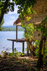 Traditional hut overlooking calm lagoon waters in the Solomon Islands.