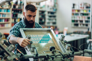 Wall Mural - Male worker using printing machine in a workshop