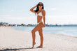 © Syda Productions - people, summer and swimwear concept - happy smiling young woman in bikini swimsuit on beach