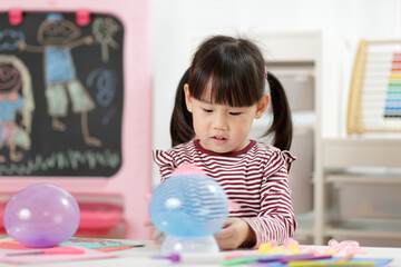 Wall Mural - young girl making balloon craft for home schooling