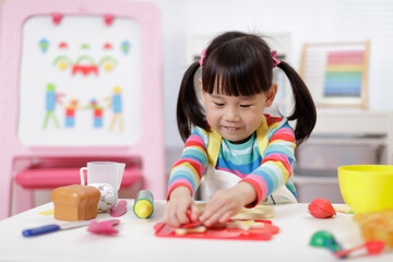 Wall Mural - young girl pretend playing food preparing at home