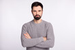 © Tetiana - Photo of young confident man serious crossed hands banker agent casual outfit isolated over grey color background