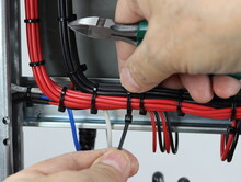 Installation Of A Cable Tie On An Insulated Mounting Wire In An Electrical Panel.