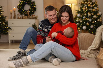 Wall Mural - Happy couple with cute baby in room decorated for Christmas