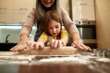 Caucasian Girl Rolling Out Dough With Grandmother