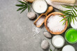 Spa product composition with cosmetics, bath salt, towel and palm leaves at stone table. Treatment, wellness concept. Flat lay image with copy space.