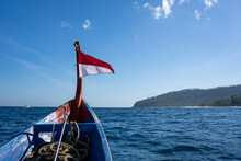 Old, Wooden Boat With A Red And White Flag Sailing In The Ocean