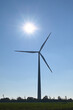 Wind turbine against background of blue sky and sun