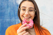 © ADDICTIVE STOCK - Young female eating delicious sprinkled donut