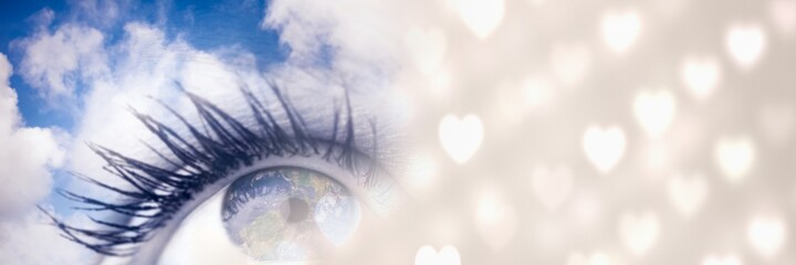 Wall Mural - Composite image of close up of a female eye and glowing heart icons on blur background