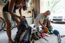 Couple Preparing Trekking Equipment In Garage