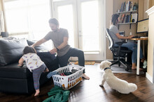 Family Working And Folding Laundry In Living Room