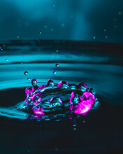 Purple Water Drops On Water Surface.