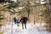 Family On Winter Hike In Snowy Forest