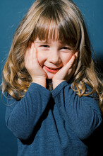 Blue Colors On A Portrait Of A Happy Little Toddler Girl Laughing