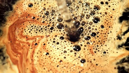 Poster - A jet of hot water pours into black coffee with air bubbles. Macro background. Filmed is slow motion 1000 frames per second.