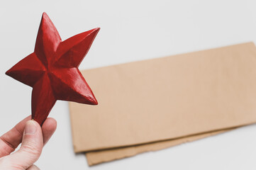 Poster - red wooden star Christmas decoration on a white and brown paper background