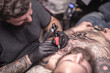 © Mr. Prof - Tattoo artist makes a tattoo on the skin in studio