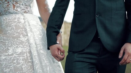 Wall Mural - A closeup of a stylish wedding couple holding hands