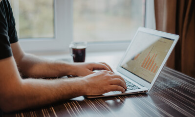 Canvas Print - Closeup shot of a person working on a laptop at a coffee shop