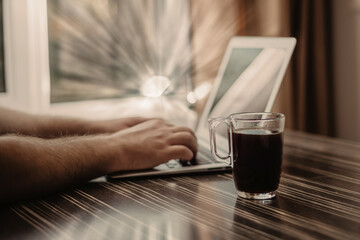 Poster - Closeup shot of a person working on a laptop at a coffee shop