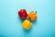 Three Fresh Bright Sweet Peppers On A Blue Background. Top View, Flat Lay