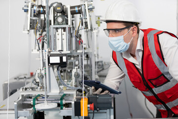 Wall Mural - male factory worker holding tablet computer and operating machine in factory