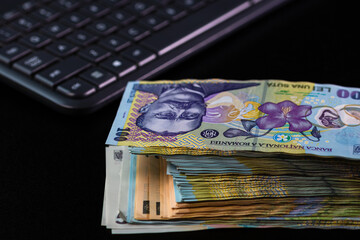 Poster - Closeup of LEI Romanian banknotes on a keyboard - online job concept