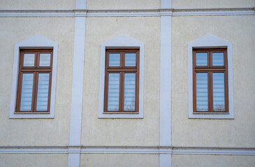 Sticker - Closeup shot of three windows next to each other on an old yellow building facade