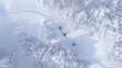 TOP DOWN: Flying above ski tourers hiking up a mountain covered in fresh snow