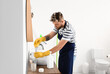 © Pixel-Shot - Handsome young man with sponge cleaning sink faucet in bathroom