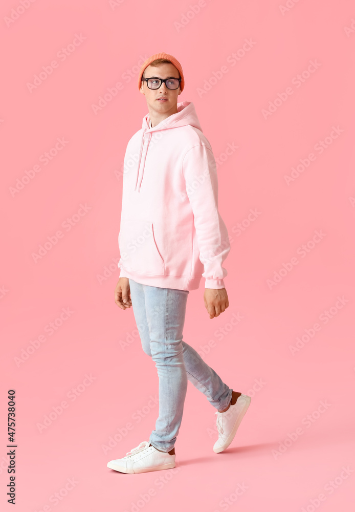 Young guy in stylish hoodie on color background