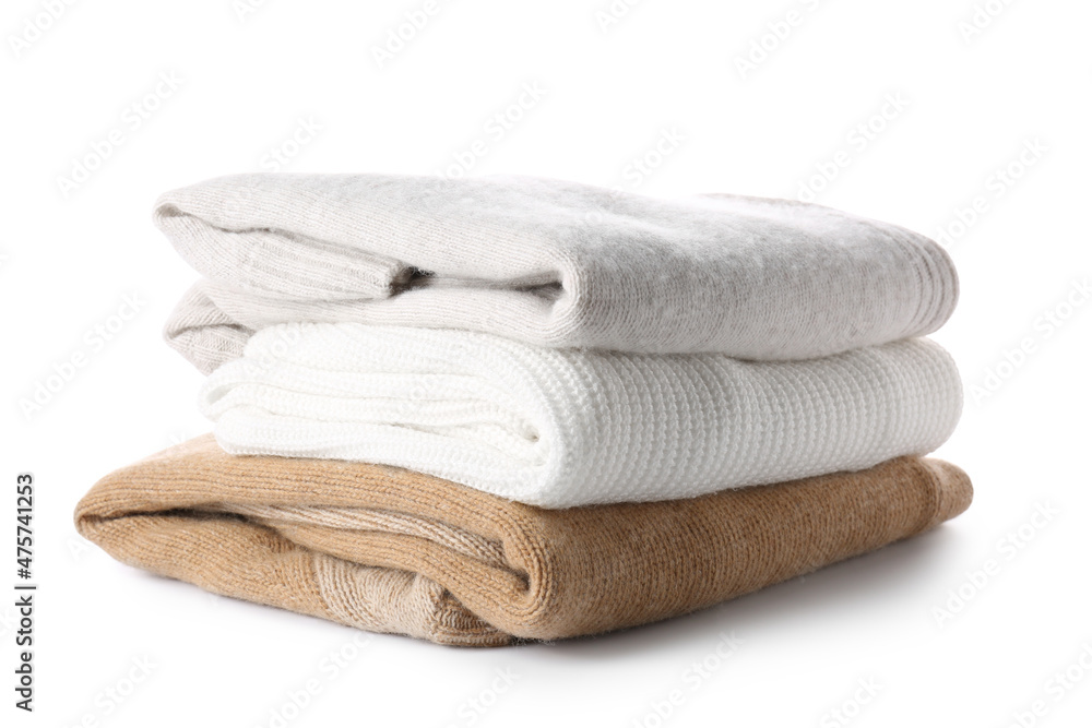 Stack of soft modern sweaters on white background