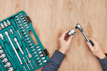 Man working in workshop using many tools. Wrench, spanner, calliper and ratchet with many attachments. Professional equipment