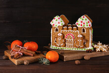 Beautiful Gingerbread House And Tangerines On Black Wooden Background