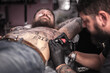 © Mr. Prof - Tattooist making tattoo in salon